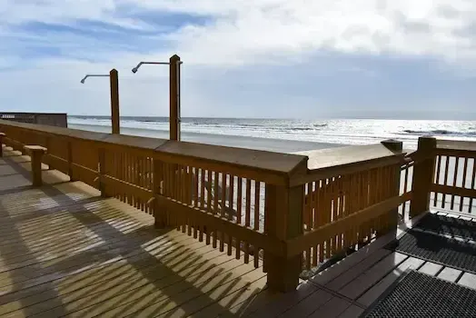 Ocean-facing deck corner with railings and shower fixtures at Atalaya Towers