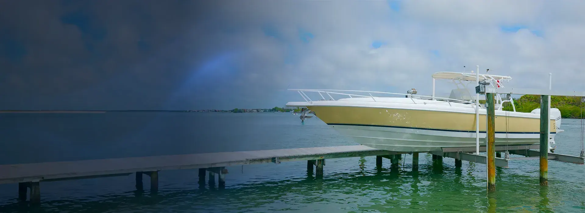 Boat supported on a lift beside a fixed waterfront dock