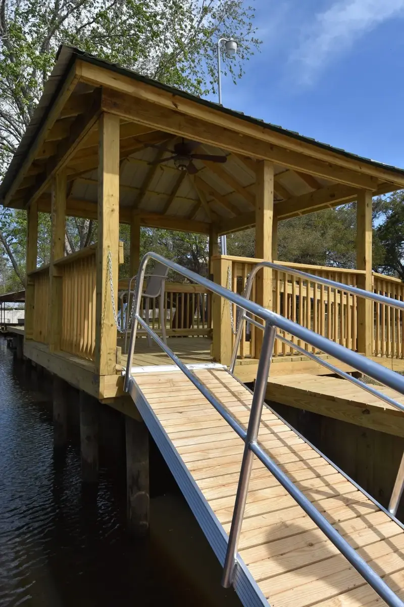 Waterbridge timber covered pierhead with a roof, ceiling fan, and aluminum gangway