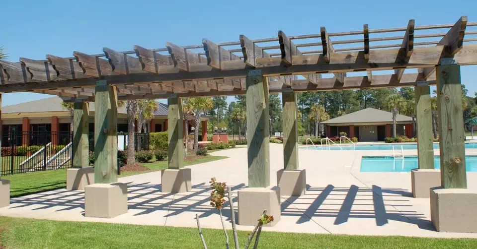 Timber pergola supported beside a community pool