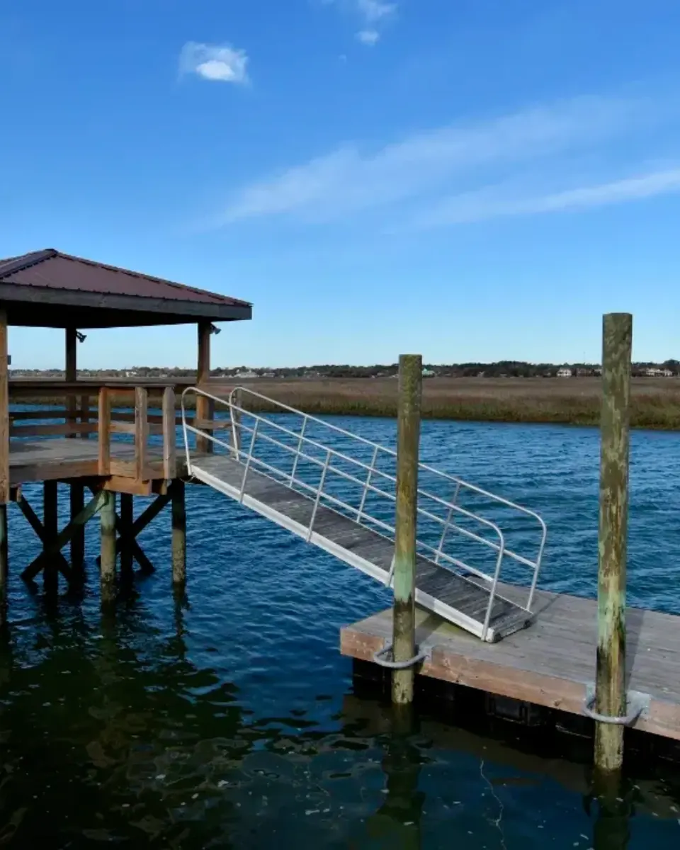 Aluminum gangway connecting a covered fixed pierhead to a timber floating dock