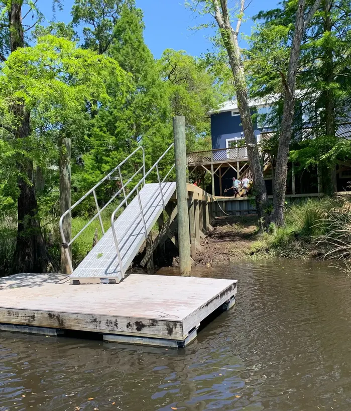 Floating dock connected to shore by an aluminum gangway and restrained by guide piles