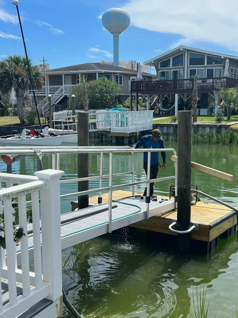 Crew installing a floating dock, guide piles, and aluminum gangway in Cherry Grove