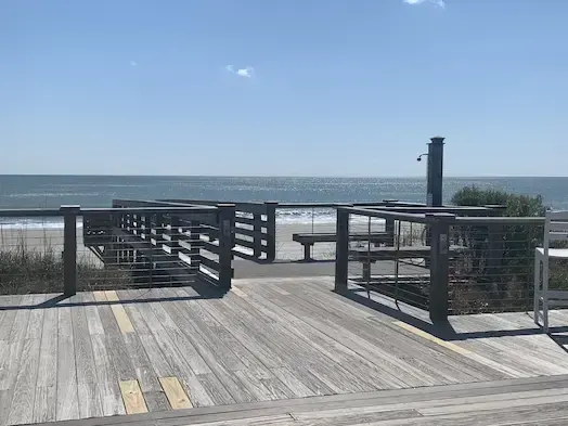 Oceanfront timber deck and railing at Litchfield by the Sea with the beach beyond