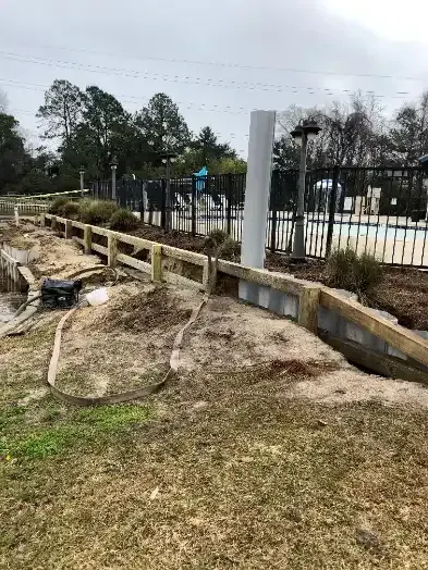 Bulkhead construction in progress beside the pool fence at Mingo Town Homes