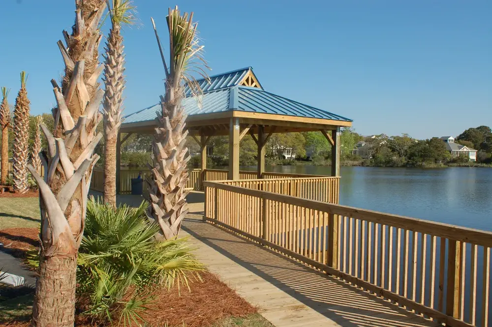Timber waterfront gazebo beside a pond with a connected walkway and terrace