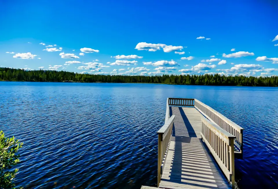 Wooden pier with railings extending over a lake