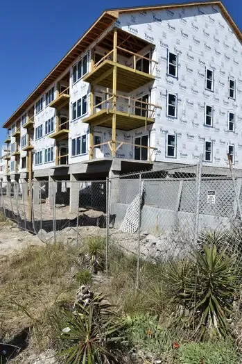 Sea Oats exterior and balconies behind a construction fence