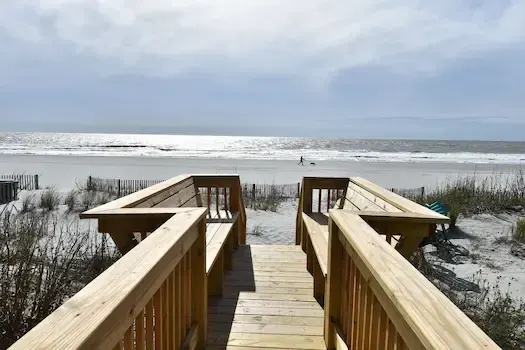 Timber dune walkway leading toward the ocean at a Surfside Beach house