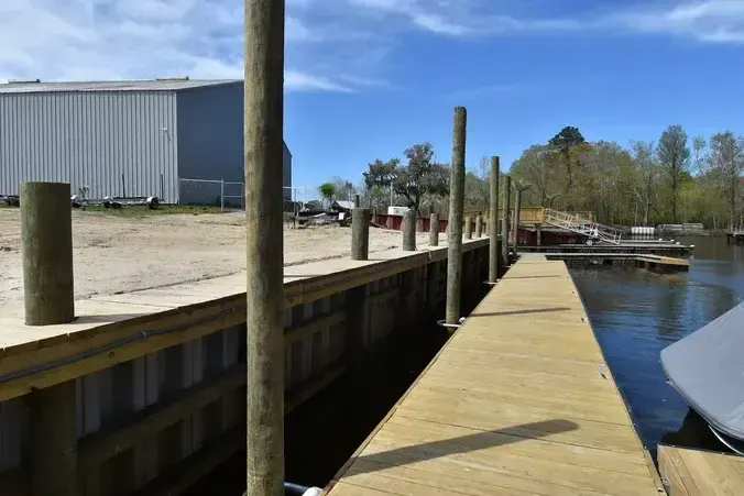 Vinyl bulkhead and timber cap beside a dock at Wacca Wache Marina
